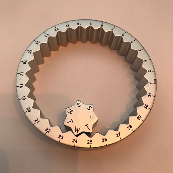 Настолен вечен календар от метал във формата на пръстен с колело.